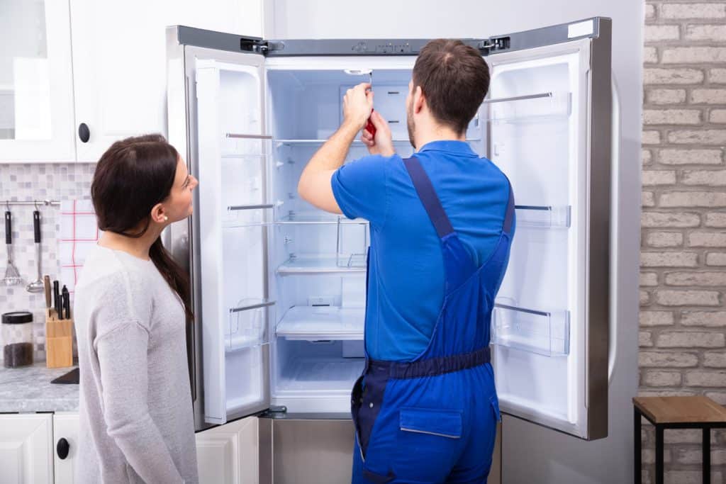 Repairman Fixing Refrigerator